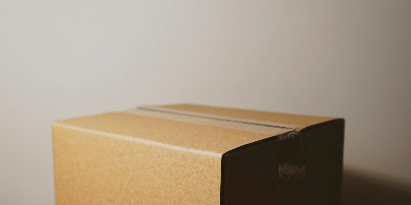 A taped cardboard shipping box on a table.